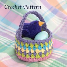 a crochet basket with an egg in it and a blue bird on top