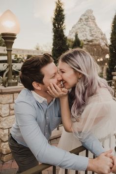 a man and woman kissing while sitting on a bench