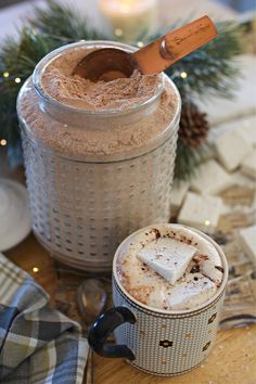 there is a cup of coffee and a cookie in the jar on the table next to it