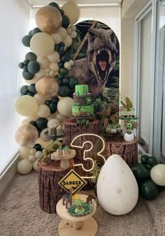 a dinosaur themed birthday party with balloons and decorations on the wall, including an egg