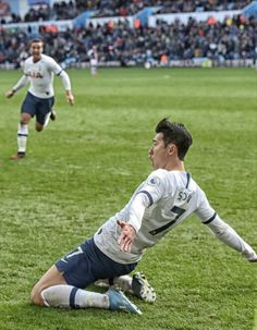 a soccer player dives for the ball during a game