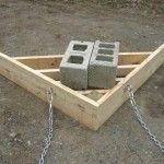 a wooden box with chains attached to it and some concrete blocks in the back ground