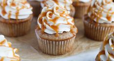 there are many cupcakes with white frosting and caramel drizzle on them