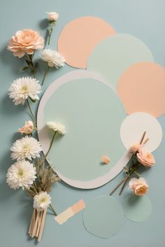 flowers are arranged on top of a mirror with pastel colors and paper circles around it