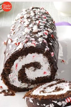 a chocolate cake roll with white frosting and peppermint sprinkles