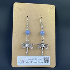 a pair of dragonfly earrings with blue beads