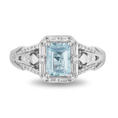 an aqua blue topazte and diamond ring with white diamonds on the sides, set in