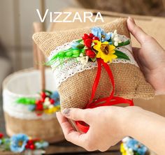 a hand holding a pillow with flowers on it and the words vitazza written above it