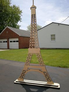 a model of the eiffel tower is shown in front of a house and driveway