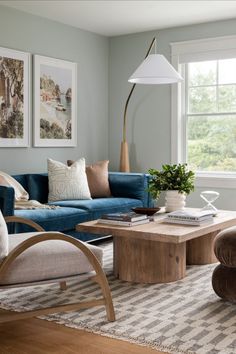 a living room filled with furniture and a lamp on top of a wooden coffee table