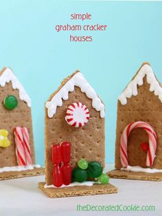 three gingerbread houses with candy canes and candies