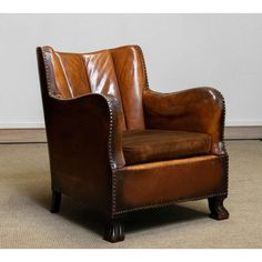 a brown leather chair sitting on top of a carpeted floor