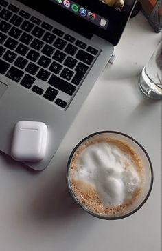 an open laptop computer sitting on top of a table next to a cup of coffee