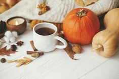 a cup of coffee surrounded by autumn decorations