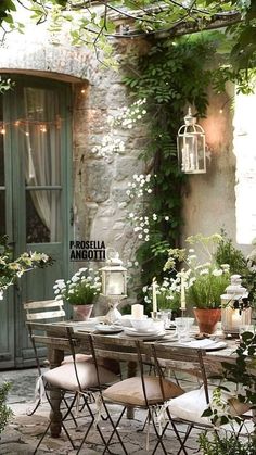 an outdoor dining area with chairs and table surrounded by greenery, potted plants and flowers