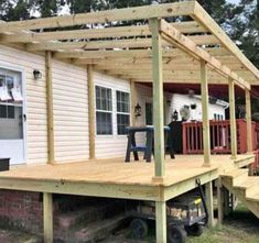 a house that is being built with wooden decking and attached to the side of it