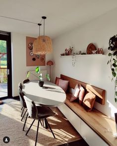 a dining room table with chairs and a bench in front of the sliding glass door