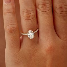 a woman's hand with a diamond ring on top of her finger and an engagement band