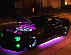 a car with its hood up is parked on the side of the road at night