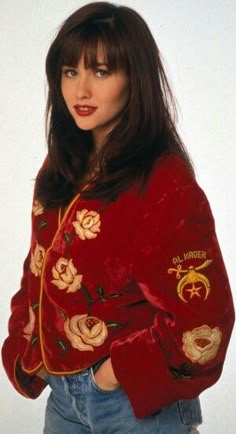 a woman wearing a red jacket with roses on it