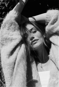 a black and white photo of a woman laying on the ground with her arms behind her head