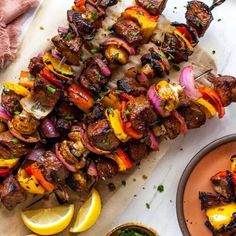 skewered meat and vegetable kabobs on a white table