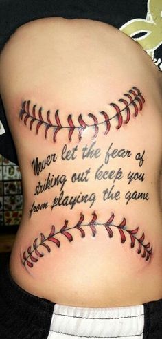 the back of a woman's stomach with a baseball tattoo that reads, never let the fear of sinking out keep you from playing the game