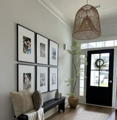 a living room with pictures on the wall and a bench in front of the door