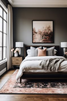 a large bed sitting in a bedroom next to two lamps and a painting on the wall