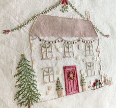 a hand embroidered house with christmas decorations on it