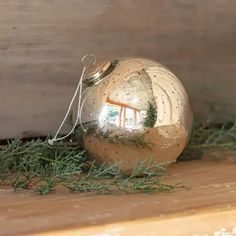 an ornament is sitting on the shelf next to some green leaves and grass