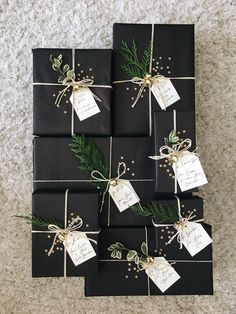 black wrapped presents tied with twine and pine needles are sitting on the floor next to each other