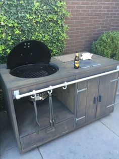 an outdoor bbq grill with two bottles of beer