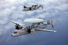 two planes flying in the air with propellers on their wings, and one is upside down