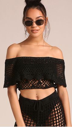 a woman wearing sunglasses and a top with fishnet net on the bottom, standing in front of a white background