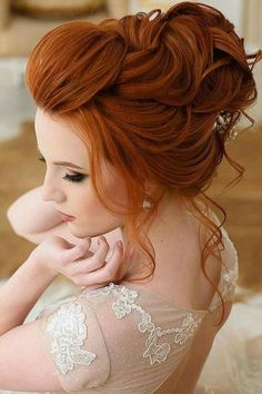 a woman with red hair is sitting on the floor wearing a wedding dress and holding her hand near her face