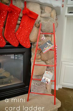 a red ladder is next to a fireplace with stockings on it and a fire place