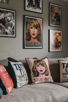 a living room filled with lots of pillows on top of a gray couch next to pictures