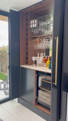 a bar with wine glasses and liquor bottles on the counter in front of a sliding glass door