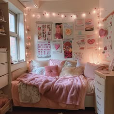 a bedroom with lights strung above the bed and pictures on the wall behind the bed