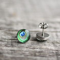 "Lovely pair of handmade earrings with a vivid green peacock feather design. Perfectly fits for everyday wearing to office and for any other occasions. Made of 100% hypoallergenic SURGICAL STAINLESS STEEL and RESIN. More PEACOCK: http://etsy.me/1q38DZK More STUD earrings: http://etsy.me/Ym7FfT DIMENSIONS Available in 3 sizes: - 7mm / 10 mm / 12 mm (0.27\" / 0.4\" / 0.5\") in diameter MATERIALS - glossy, jewelry grade resin, that makes the earrings durable but light weight, as well as water resis Green Round Plug Earrings As Gift, Green Round Plug Earrings Gift, Round Peacock Design Earrings As Gift, Green Peacock Design Jewelry Gift, Handmade Peacock Color Jewelry As Gift, Handmade Peacock Jewelry Gift, Handmade Peacock Jewelry As Gift, Round Peacock Design Jewelry Gift, Peacock Feather Jewelry