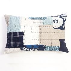 a blue and white patchwork pillow on a white background