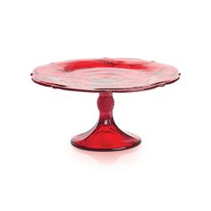 a red glass cake plate sitting on top of a white table