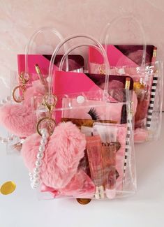 a pink purse filled with lots of items on top of a white table next to a mirror