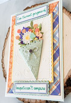 a close up of a card on a tree stump with flowers in the center and words underneath it