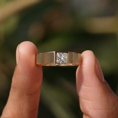 a person holding a diamond ring in their hand