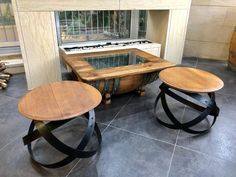 two wooden tables sitting next to each other in front of a window on top of a tile floor