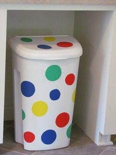 a polka dot trash can sitting on the floor