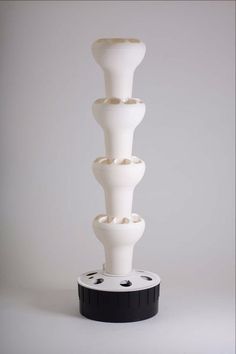 a tall white vase sitting on top of a black base