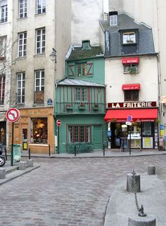 a street corner with shops and buildings in the background